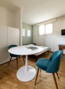 una camera con un tavolo, due sedie e un letto di Amazing studio in San Babila a Milano