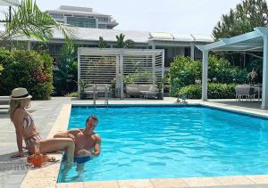 a man and a woman sitting in a swimming pool at Rosedon in Hamilton