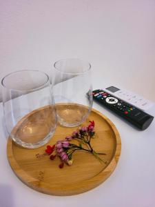 two wine glasses and a remote control on a cutting board at Pousada Vilarejo in Caraíva