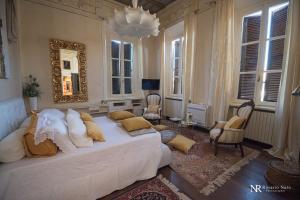 a bedroom with a white bed in a room with windows at Villa Ghiringhelli in Azzate