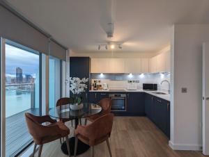 a kitchen with a table and chairs and a kitchen with a view at Southampton Waterside by Charles Hope in Southampton