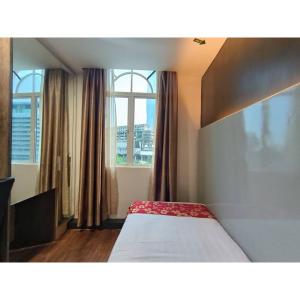 Bett in einem Zimmer mit einem großen Fenster in der Unterkunft Sakura Elite Kuala Lumpur in Kuala Lumpur