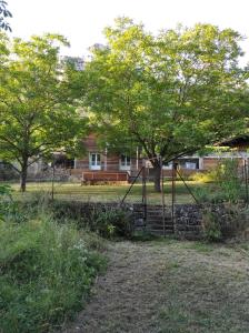 un columpio en un parque con árboles y un banco en Maison au bord de l'eau avec Jacuzzi, en Millau