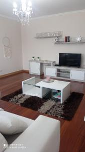 a living room with a white table and a tv at A Eira de Salvador in Portas