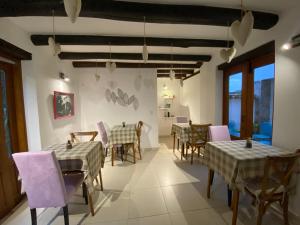 una sala da pranzo con tavoli, sedie e sedie viola di Hotel El Embrujo a Villa de Leyva
