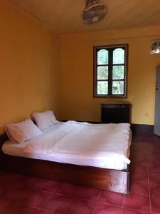 een groot bed in een slaapkamer met een raam bij Somewhere over the river in Ban Houayxay
