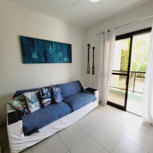 niebieską kanapę w salonie z oknem w obiekcie Apartarmento Ar Con - WIFI - Garagem - Piscina - Enseada Guarujá w mieście Guarujá