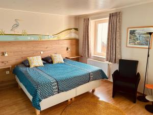 1 dormitorio con 1 cama y 1 silla en Taos B&B en Vresse-sur-Semois