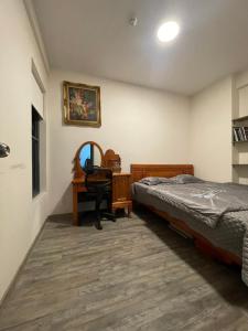 Ấp Phú ThọDuctaigallery's Entire Apt & Happy One Building的卧室里有一张床、一张书桌和一面镜子