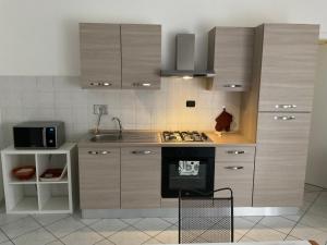 a kitchen with wooden cabinets and a stove and a sink at Appartamento Repubblica 2 in Prato