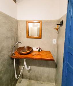 a bathroom with a wooden sink and a mirror at Pousada Vilarejo in Caraíva