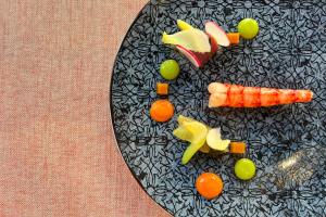 une plaque noire contenant des légumes et des fruits dans l'établissement Hotel Cordial Mogán Playa, à Puerto de Mogán