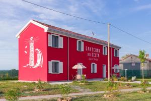 a red building with a sign on the side of it at LANTERNA DEL DELTA Guest House in Porto Tolle