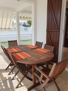 a wooden table and chairs in a room at Villa Flora, escapade champêtre in Petit-Canal +5 photos