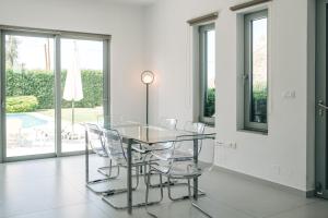 una sala da pranzo con tavolo in vetro e sedie di Selene a modern villa with private pool a Stavros