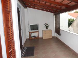 a living room with a television and a balcony at Apartment Maria in Poreč