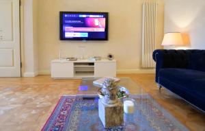 a living room with a blue couch and a tv at LA CASA DI MONIC in Pisa