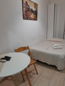 a small room with a bed and a table and chair at Palma Residence in Rome