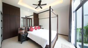 a bedroom with a large bed with red pillows at Saiyuan Estate by TropicLook in Rawai Beach