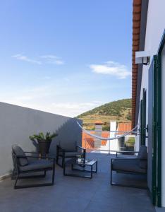 a balcony with chairs and a view of the ocean at By the hill in Ribeira Grande
