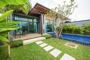 a house with a swimming pool and a garden at Saiyuan Estate by TropicLook in Rawai Beach