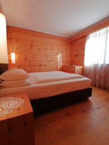 a bedroom with a bed and a wooden wall at Casa Mariella - Apartment with garden in Tesero