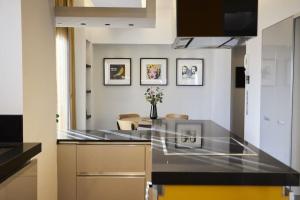 a kitchen with a black counter top and a living room at A3_Aplotaria Architect's Apartment in Chios