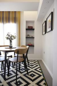 een eetkamer met een tafel en stoelen op een tapijt bij A3_Aplotaria Architect's Apartment in Chios