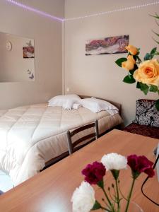 a bedroom with two beds and flowers on a table at Studio near University of Thessaly in Larisa