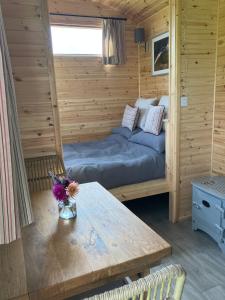 a bedroom with a bed and a table in a room at Shepherd's Huts in Barley Meadow at Spring Hill Farm in Oxford