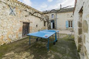 una mesa de ping pong en un patio en un edificio antiguo en Le Presbytère de Pompiac, en Castillonnès