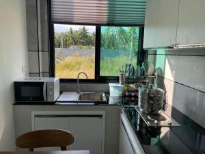 a kitchen with a sink and a microwave at Baan pakiet&Khun jang in Ban Nam Lai Ta Tum