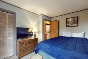 a bedroom with a blue bed and a television at Bee Branch 44 in Sugar Mountain