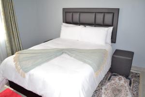 索韋托的住宿－Soldout Camp 3，卧室配有一张带白色床单和枕头的大床。