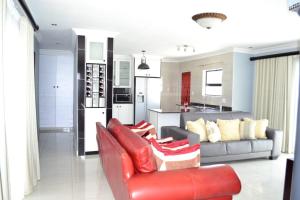 un soggiorno con divano rosso e una cucina di Soldout Camp 3 a Soweto