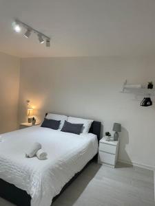 um quarto branco com uma grande cama branca com almofadas em Belfast Chic: Elegant 2BR Sleeps 5, Prime Location em Belfast