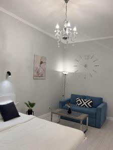 リヴィウにあるSoVA apart near Rynok squerのベッドルーム1室(青いソファ、壁掛け時計付)