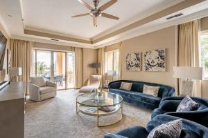 a living room with a blue couch and a table at Ocean View Residence 304 located at The Ritz-Carlton in Upper Land