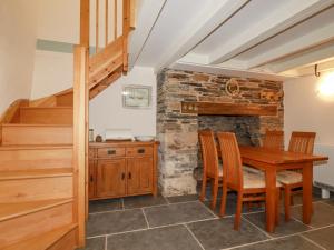 een keuken en eetkamer met een houten tafel en stoelen bij Mill Cottage in Liskeard