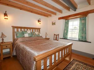 een slaapkamer met een groot bed en een raam bij Mill Cottage in Liskeard