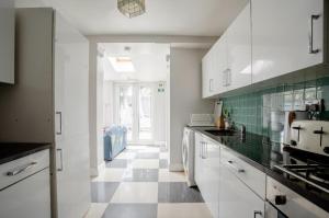 a kitchen with white cabinets and a checkered floor at London comfy doubles in London
