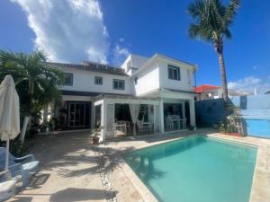 a house with a swimming pool in front of a house at B&B Villa Luna in Bayahibe