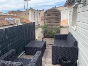 eine Terrasse mit 2 Stühlen und eine Tür auf einem Balkon in der Unterkunft Les Marionnettes, Maison de ville 80m2 avec terrasse in La Rochelle