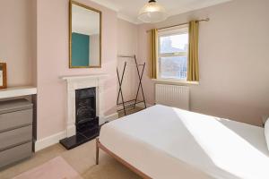 a bedroom with a bed and a fireplace at Host & Stay - Westbrook Road in Margate