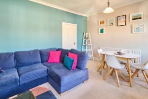 a living room with a blue couch and a table at Host & Stay - Westbrook Road in Margate