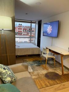 波哥大的住宿－Loft Central Zona Universitaria，配有床、桌子和电视的房间