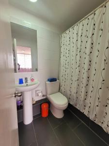 ein Badezimmer mit einem WC, einem Waschbecken und einem Spiegel in der Unterkunft ChileRuca Departamentos Amoblados in Santiago