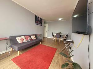 a living room with a couch and a red rug at ChileRuca Departamentos Amoblados in Santiago