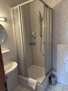 een badkamer met een douche en een wastafel bij Hotel Sonnenschein nähe Messe und Flughafen in Düsseldorf