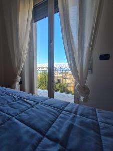 - une chambre avec un lit et une grande fenêtre dans l'établissement La Finestra Sul Golfo, à Ercolano